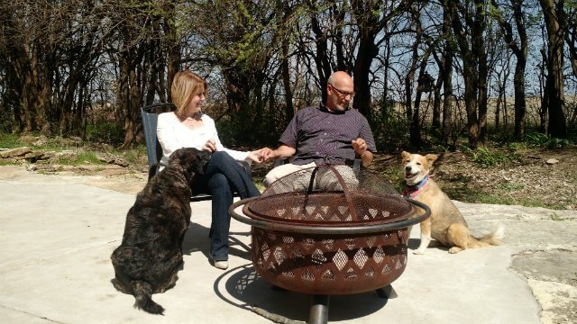 Owner, Ann Grammon, her husband, and two dogs sitting around a fire pit